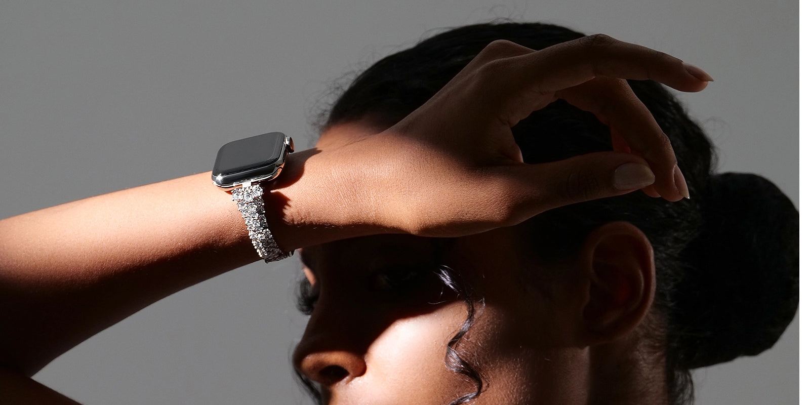 A silver Apple Watch band elegantly set with zircon stones, sparkling in the sunlight for a look of understated luxury.