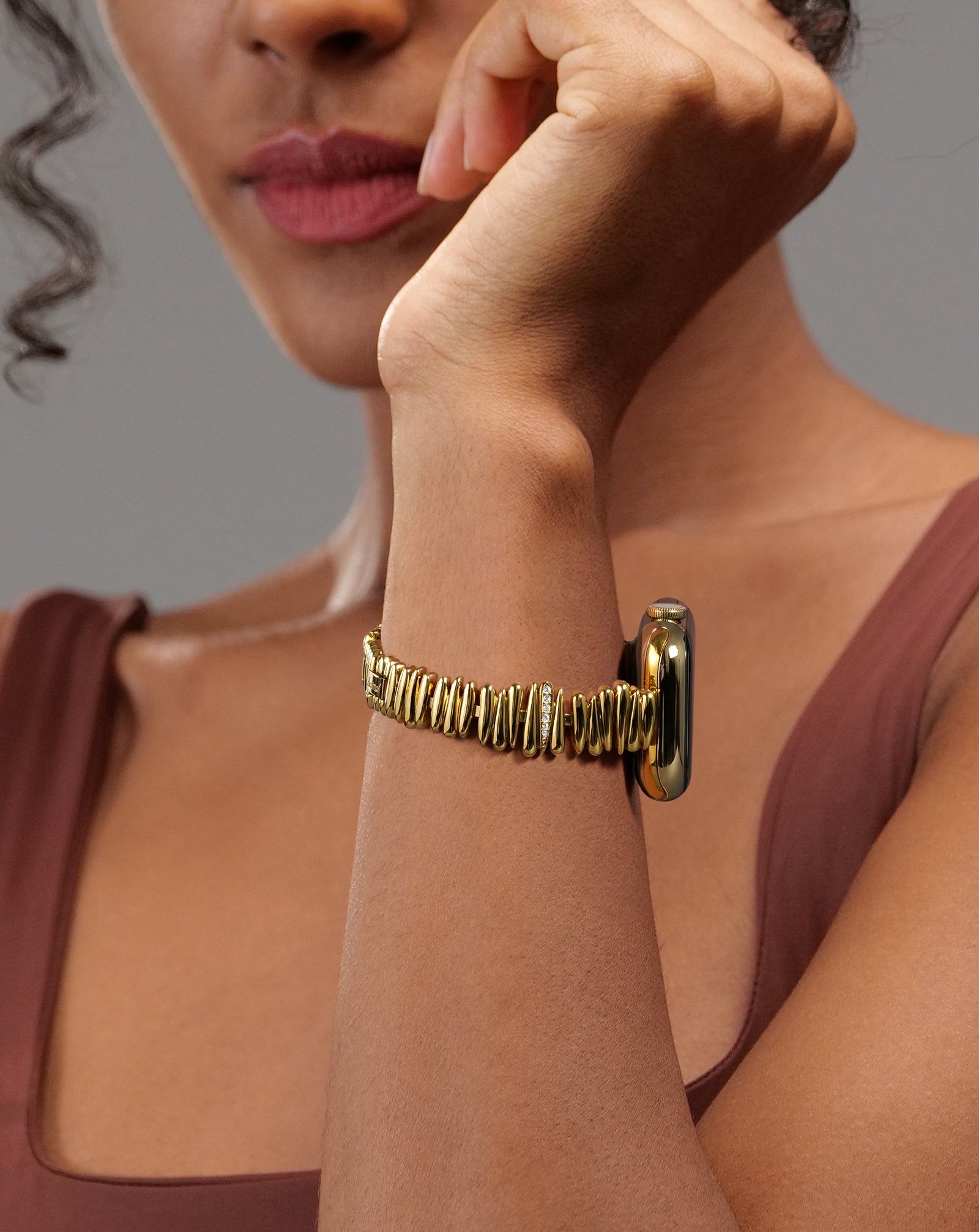 Model wearing the LUXIMAIL Golden Feather Apple Watch strap, designed like a delicate jewelry bracelet with feather details.